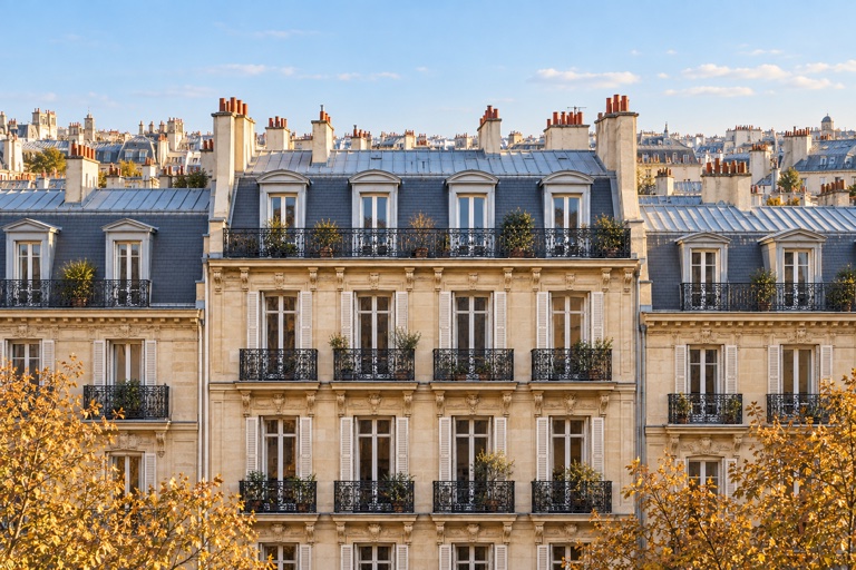 Parisian-style limestone façades, wrought-iron balconies and mansard roofs against an open skyline.